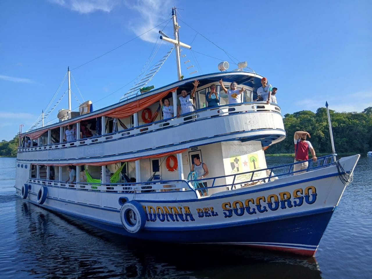 Voluntários a bordo do barco acenando