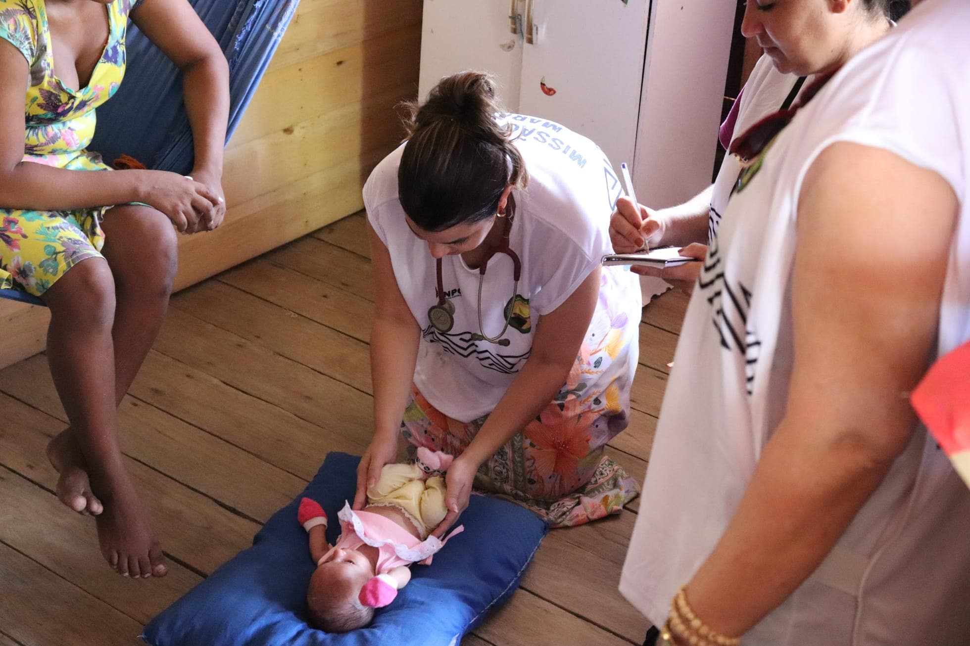 Médica voluntária atendendo um bebê em comunidade ribeirinha