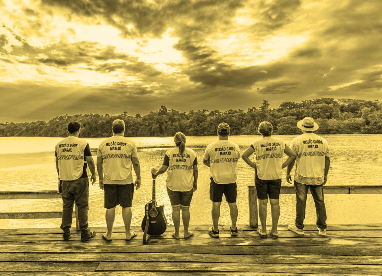 Equipe de voluntários do INPORI à beira do rio ao pôr do sol